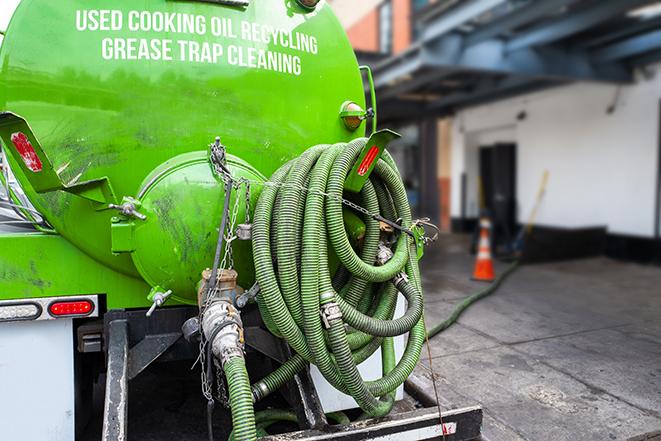 a technician pumping a grease trap in a commercial building in Broken Arrow, OK